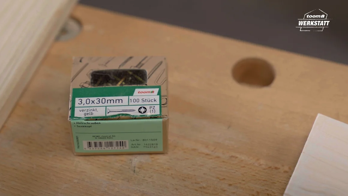 Eine Packung gelber Schrauben auf einem Holztisch