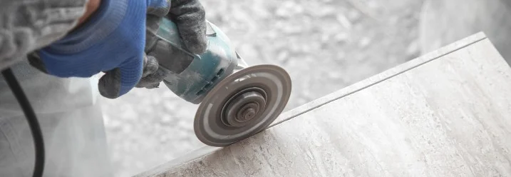Person schneidet Fliese mit Winkelschleifer