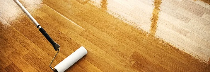 Parkettboden wird mit Rolle lackiert