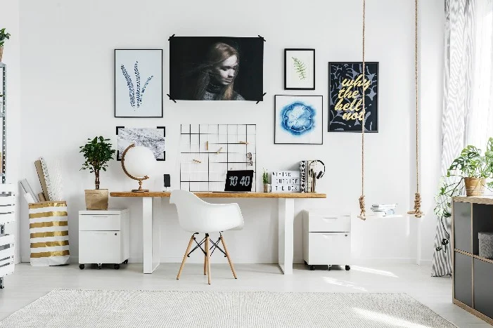 Heller Arbeitsplatz mit Schreibtisch und Bildern