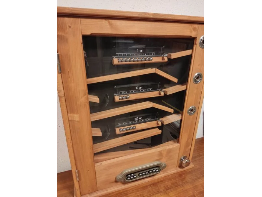 Ein Holzkasten mit drei Abakus-Rechenmaschinen darin.
