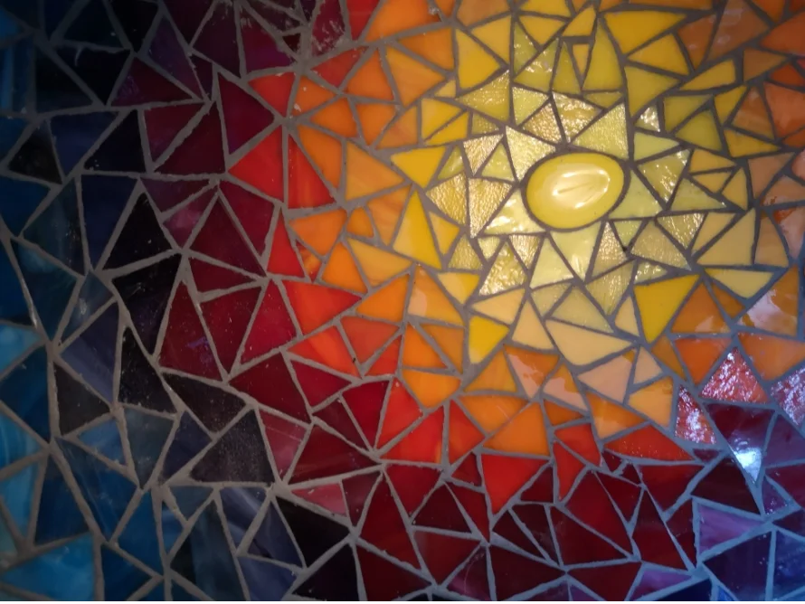 Abstraktes Mosaik mit gelber Sonne auf rotem Grund
