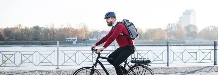 Person fährt mit Fahrrad an Fluss