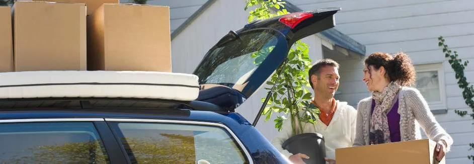 Ein Paar belädt einen Kombi mit Umzugskartons