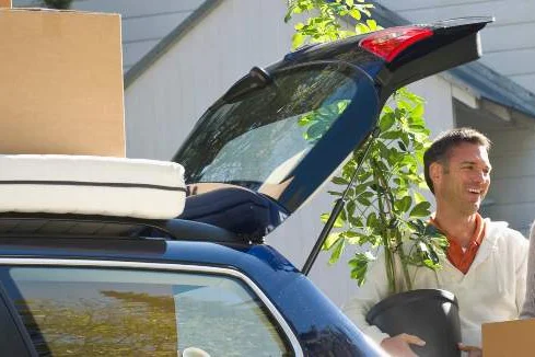 Ein Paar belädt einen Kombi mit Umzugskartons