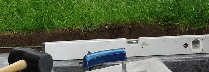 Wasserwaage, Gummihammer und Kelle auf Baustelle