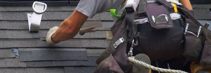 Person repariert Dach mit Hammer.