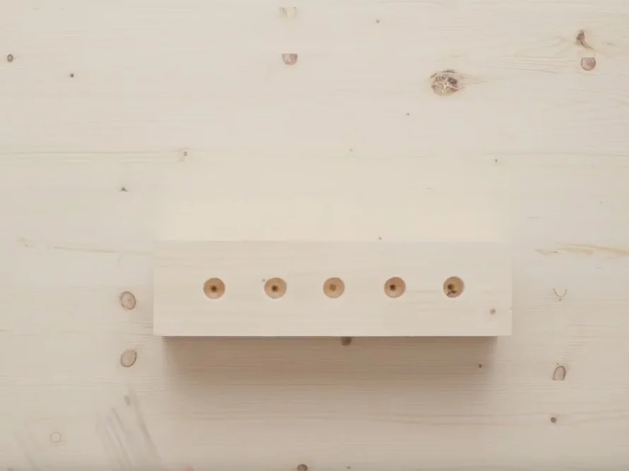 Holzstück mit fünf vorgebohrten Löchern