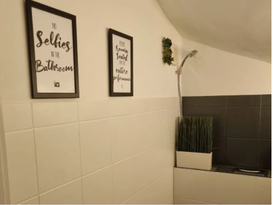 Badezimmer mit zwei Bildern an der Wand