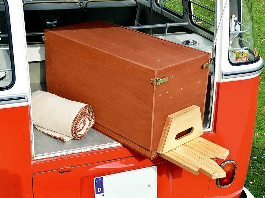 Eine Holzkiste mit ausklappbaren Beinen in einem Van