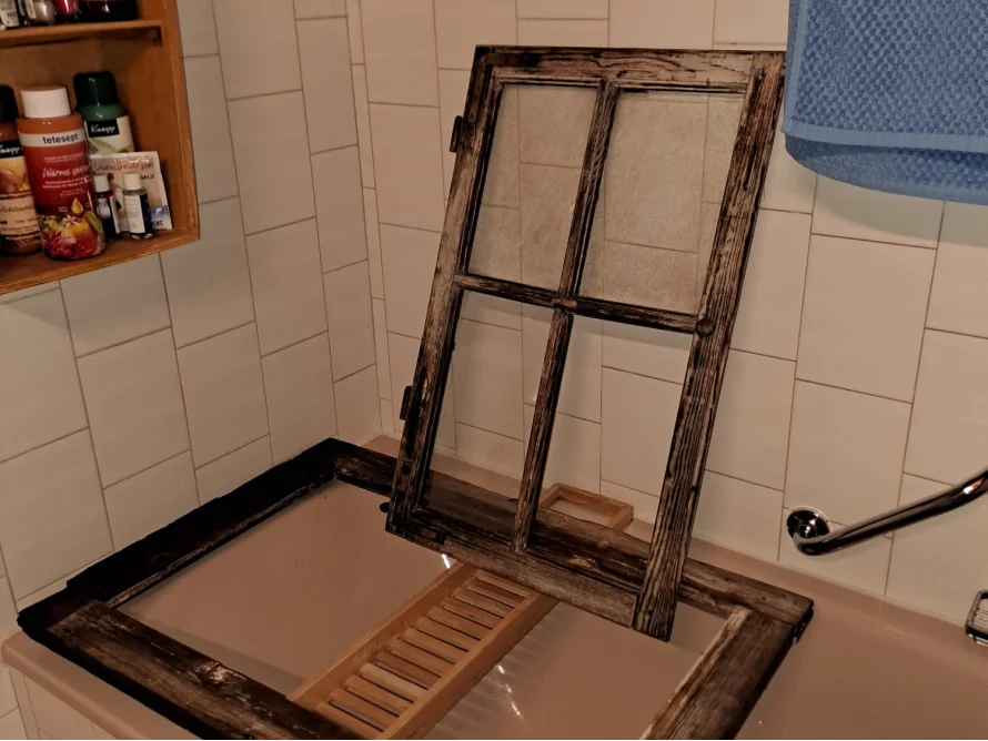 Altes Fenster liegt in Badewanne