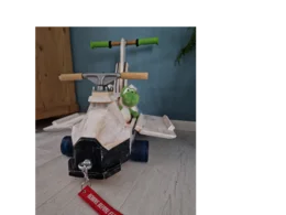 Ein Spielzeugflugzeug aus Holz mit einem Stofftier darauf