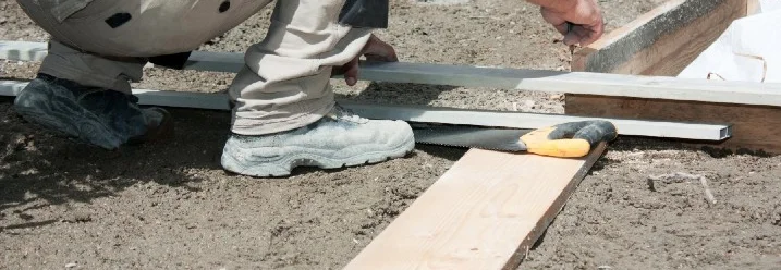 Person baut eine Schalung für eine Terrassenfundamentierung