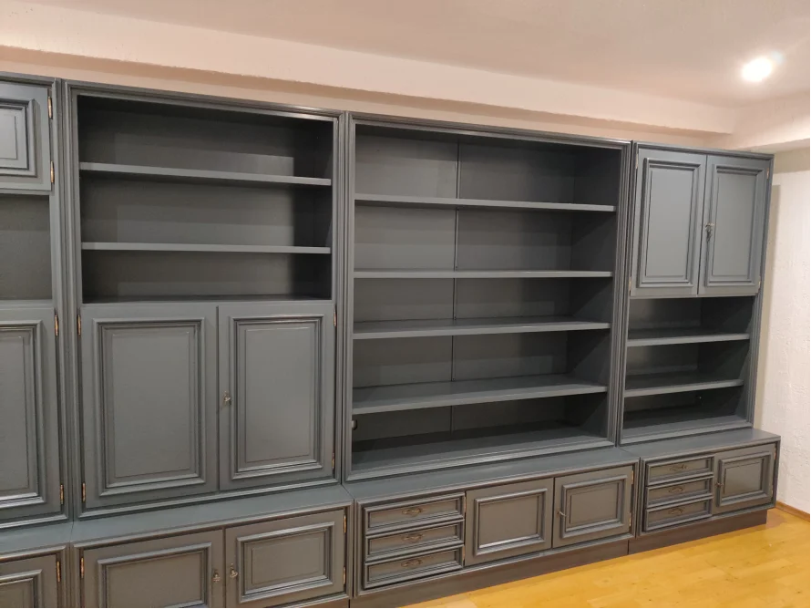 Ein großes, graues Bücherregal mit Schränken und Regalen.