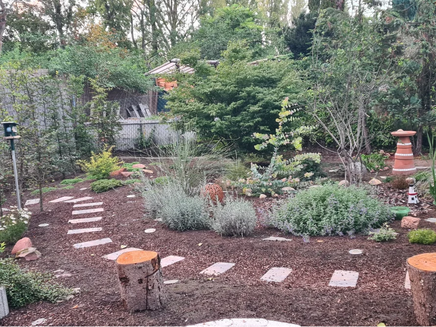Gartenweg mit Steinen und Baumstämmen