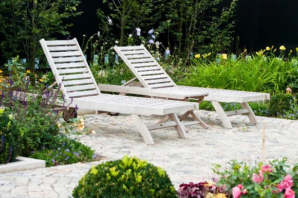Zwei Liegestühle in einem Garten