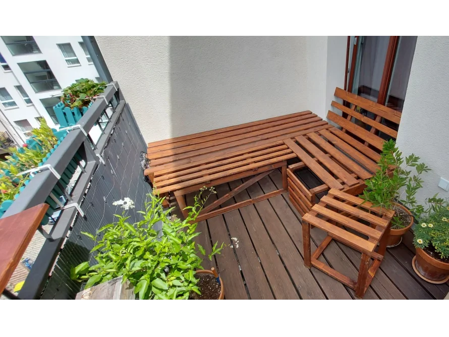 Ecke eines Balkons mit einer Sitzecke aus Holz