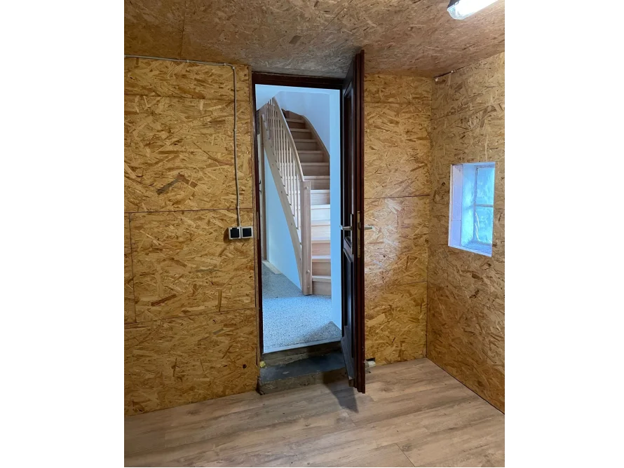 Zimmer mit Holzvertäfelung und Holztreppe