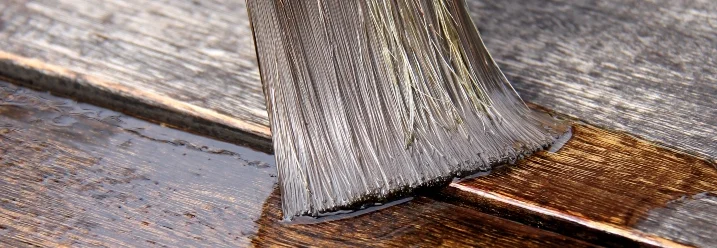 Pinsel trägt Holzschutz auf