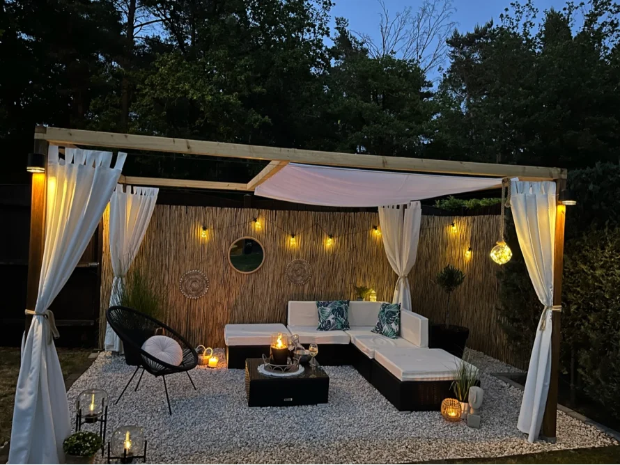 Gemütliche Sitzecke mit Überdachung im Garten bei Nacht