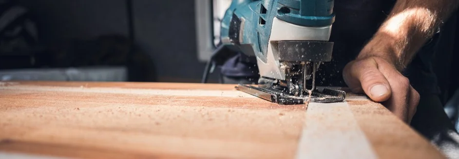 Person sägt Holz mit Stichsäge