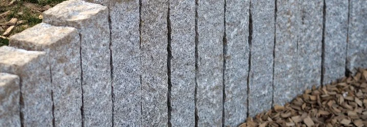 Palisaden aus Granit säumen ein Hochbeet