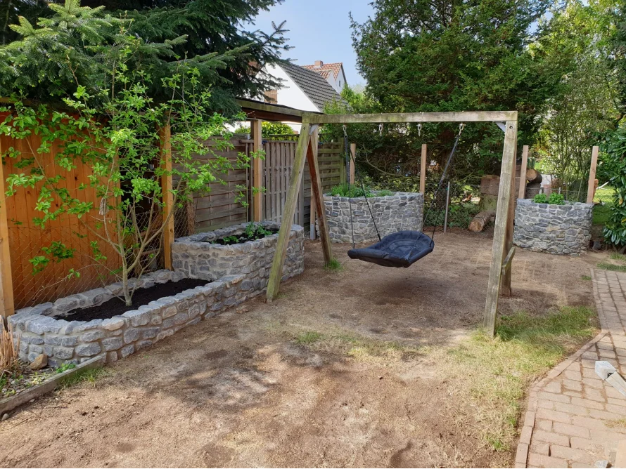Garten mit Schaukel und Hochbeeten