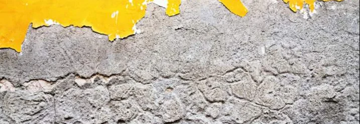 Abblätternde gelbe Farbe auf einer Wand