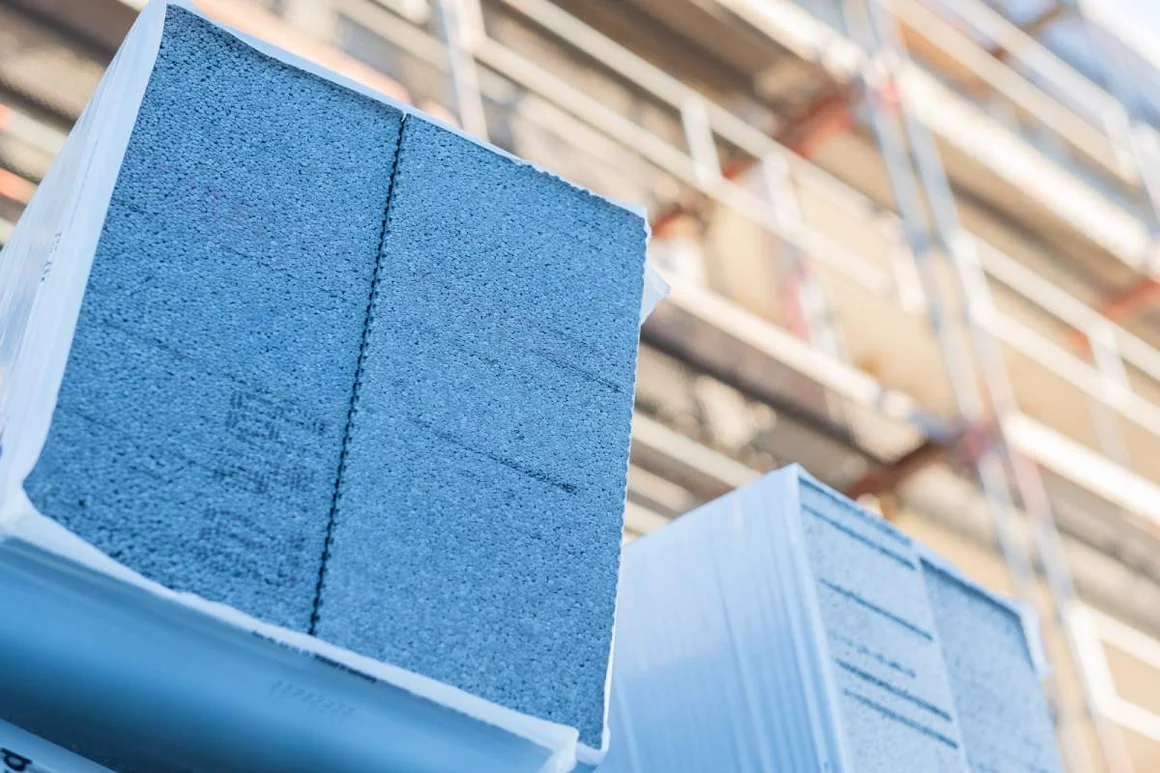 Nahaufnahme von verpackten Dämmplatten auf einer Baustelle.