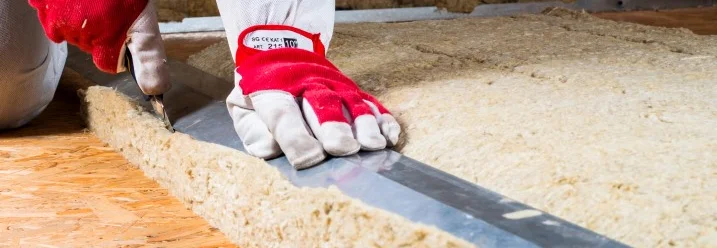 Person schneidet Dämmmaterial mit Cuttermesser