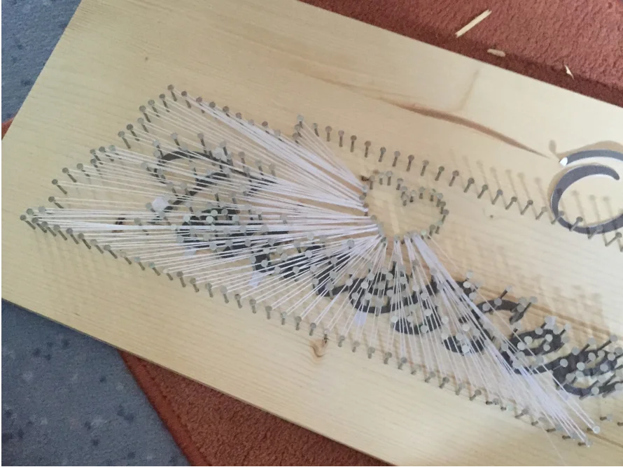 Fadengrafik mit Nägeln auf Holz