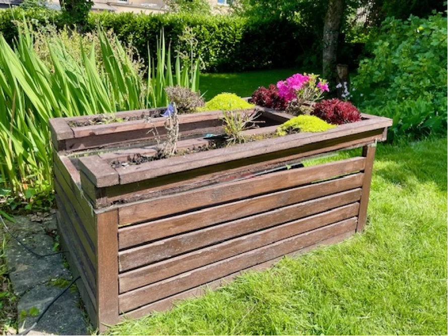Holzgestell mit Blumen im Garten
