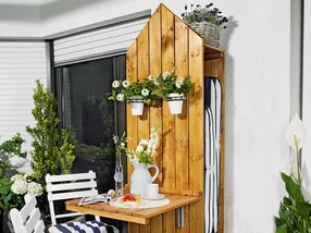 Holz-Sichtschutz mit Klapptisch und Blumen