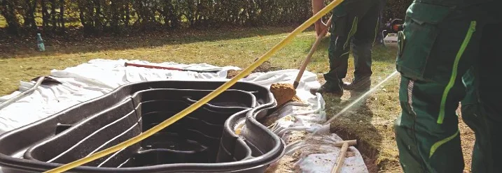 Zwei Personen setzen einen Teich ein