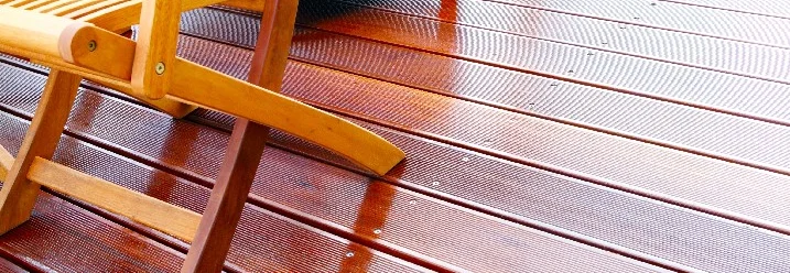 Nasse Holzterrasse mit Gartenmöbeln
