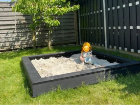 Kind mit Eimer in einem Sandkasten