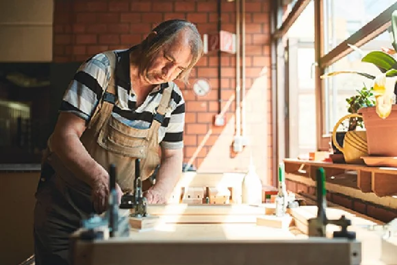 Person bearbeitet Holz mit Hobel