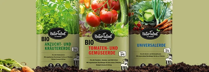 Drei Säcke Blumenerde auf einem Erdhaufen