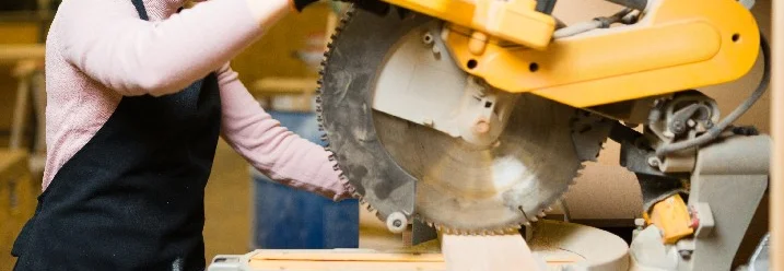 Person sägt Holz mit Kreissäge