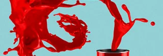 Rote Farbe spritzt aus Farbeimer