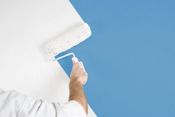 Person streicht Wand weiß