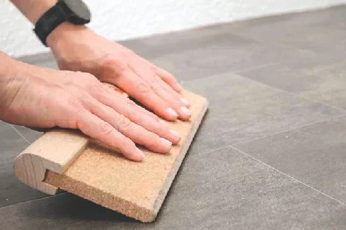 Person verlegt PVC-Boden mit Andrückroller