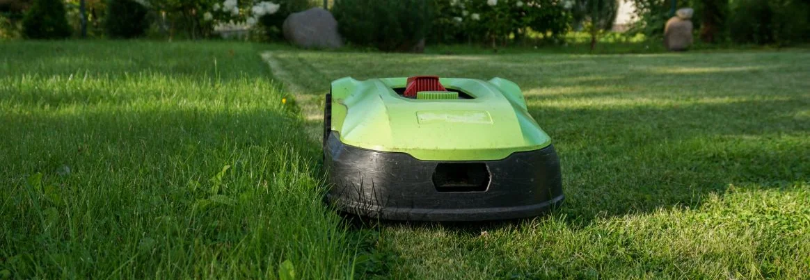Ein Mähroboter mäht den Rasen im Garten.