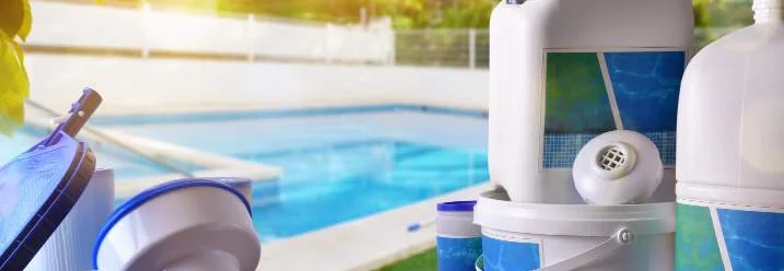 Zubehör zur Poolreinigung und Wasserpflege am Rande eines Pools.
