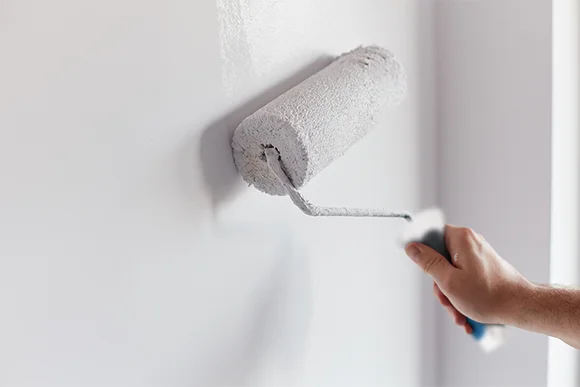 Person streicht Wand weiß