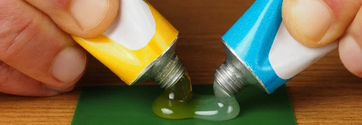 Beide Tuben eines Zwei-Komponenten-Klebers in Benutzung