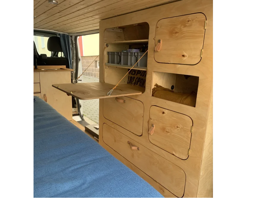 Eingebautes Schranksystem aus hellem Holz in einem Van