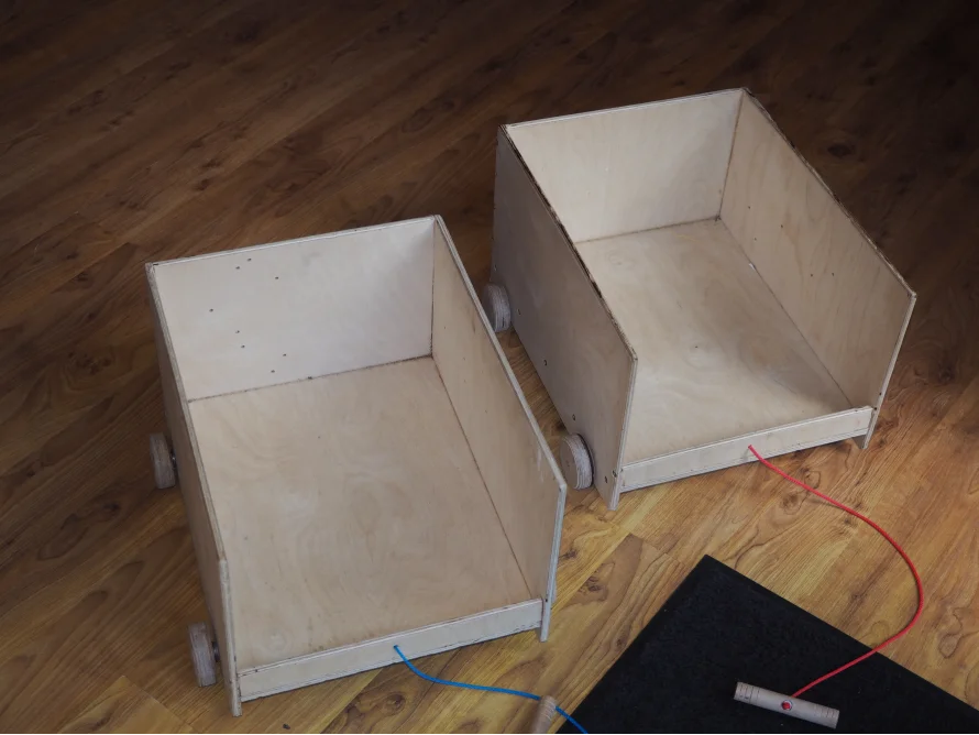 Zwei Spielzeugwagen aus Holz mit Zugschnur