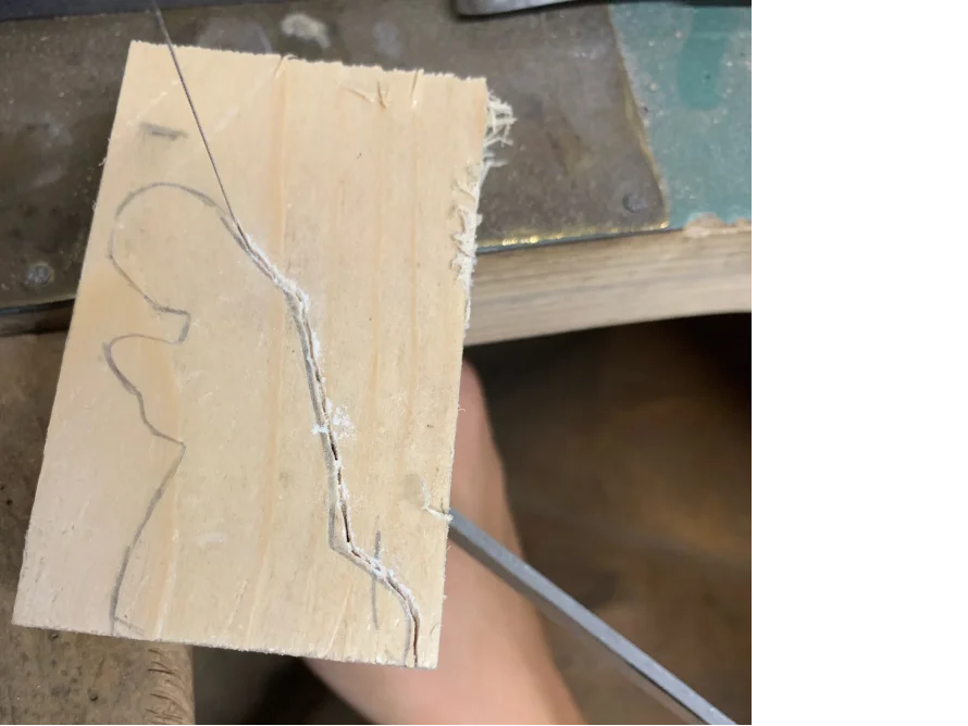 Laubsäge schneidet Form aus Holz