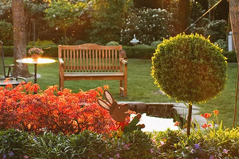 Garten mit blühenden Pflanzen und Gartenmöbeln